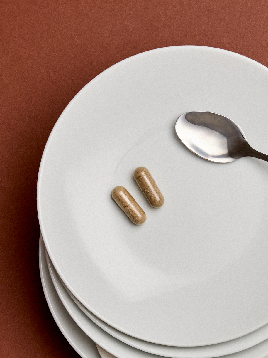 Arrae Bloat capsules on a plate with a spoon